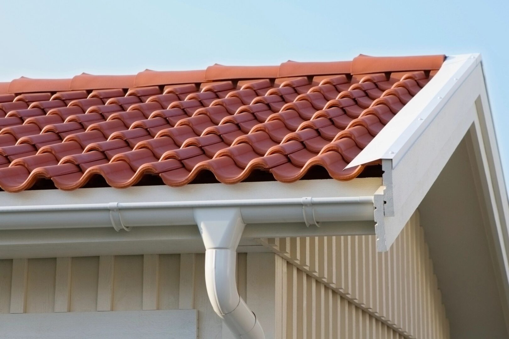 A red tile roof with gutter and rain gutters.