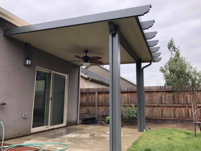 A patio cover with a fan and lights on the side.